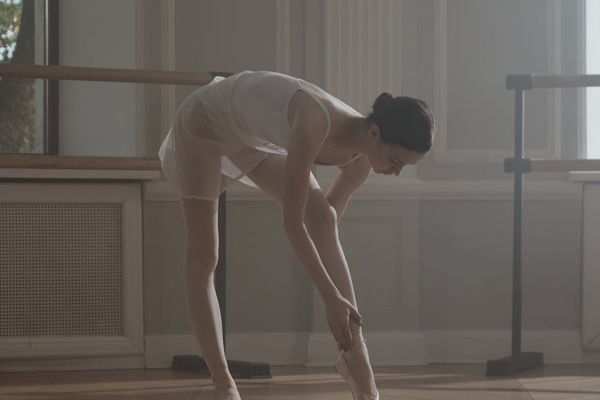 A person calmly performing an exercise in a minimalist room.